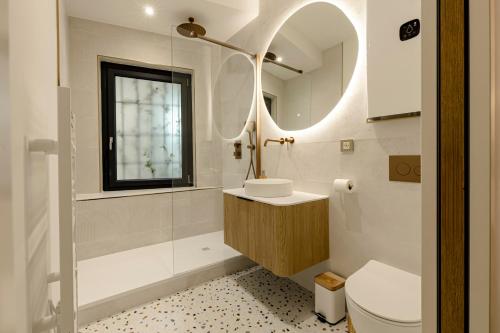 Un baño con lavabo, inodoro y espejo. en L'Instant Nîmois, en Nimes