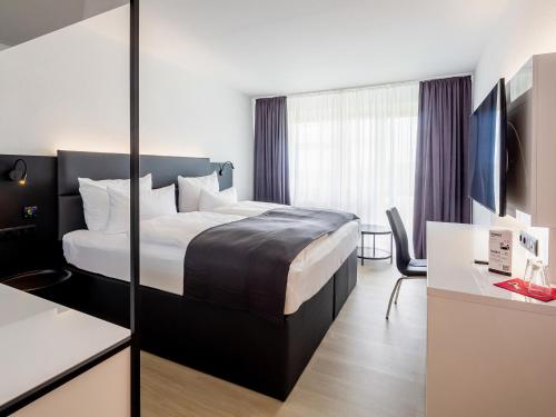 Ένα ή περισσότερα κρεβάτια σε δωμάτιο στο DORMERO Hotel Weimar