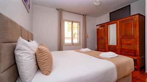 Un dormitorio con una cama blanca grande y una ventana en Casa Conceição, en Ribeira Brava