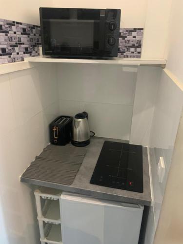 une petite cuisine avec un micro-ondes et une cuisinière dans l'établissement Quiet and lovely Paris Center, à Paris