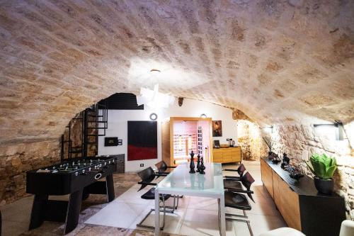 a room with a stone wall and a table and chairs at Dimora San Rocco in Molfetta