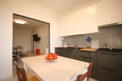 a kitchen with a table with a bowl of fruit on it at Grazioso appartamento non lontano dal mare in Trappeto