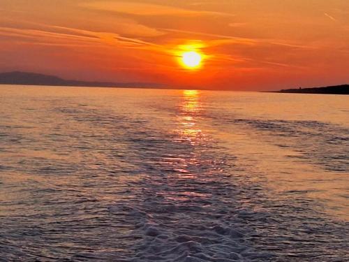 a sunset over a body of water at Apartments Marija in Vela Luka