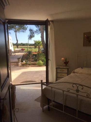 a bedroom with a bed and a sliding glass door at Masseria Battaglini in Martina Franca