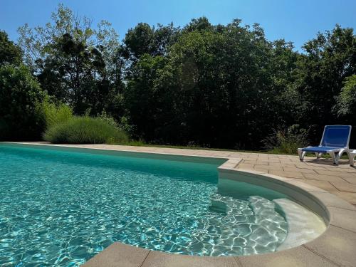 une chaise bleue assise à côté d'une piscine dans l'établissement La Treille, à Saint-Hilaire-du-Bois