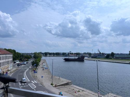 a river with a large boat in the water at Villa Concha-Apartamenty Bryza-Parking in Świnoujście