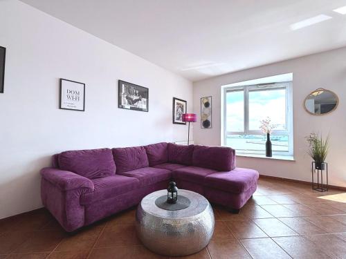 a purple couch in a living room with a table at Villa Concha-Apartamenty Bryza-Parking in Świnoujście