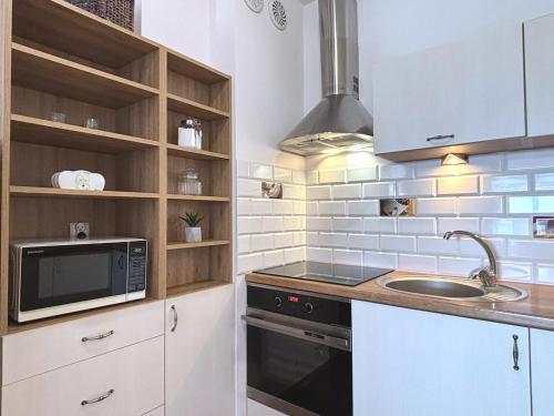 a kitchen with a microwave and a sink at Villa Concha-Apartamenty Bryza-Parking in Świnoujście