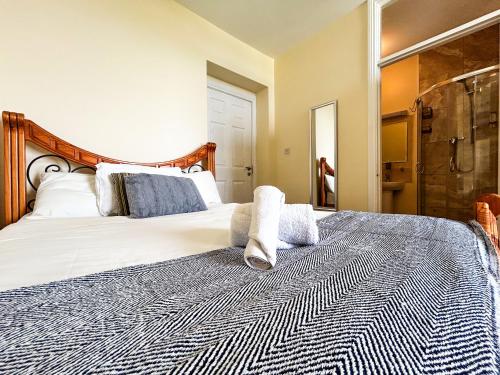 a bedroom with a large bed with towels on it at Coach House Lodge in Lahinch