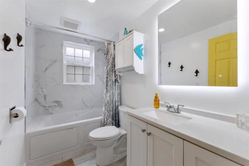 Un baño blanco con lavabo e inodoro. en 309 E Hildreth Ave, Unit 1, en Wildwood