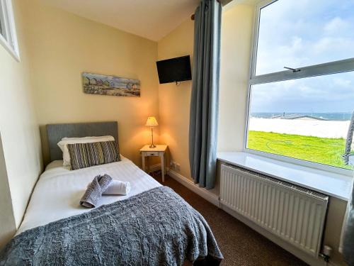 a bedroom with a bed and a large window at Coach House Lodge in Lahinch