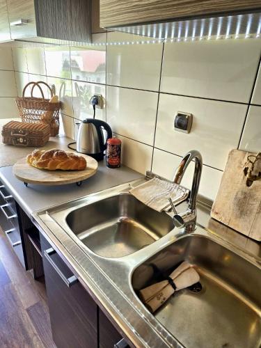 a kitchen with a sink and a plate of bread at Grota zbójnicka apartament i pokoje in Gliczarów