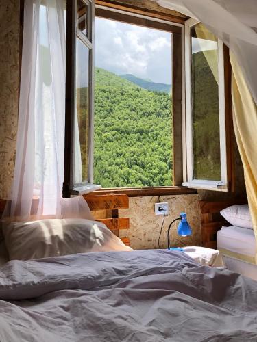 a bedroom with a bed and a large window at Ela in Ushguli