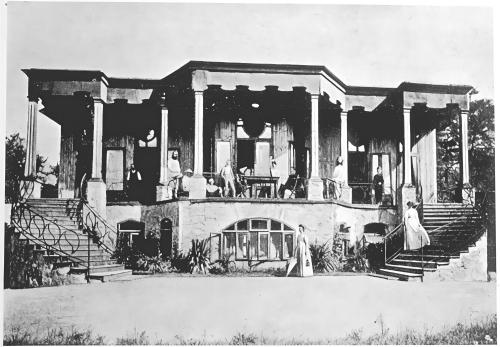 an old photo of a house with people sitting on the porch at Hotel Monte Verità in Ascona