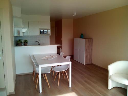 a small kitchen with a white table and chairs at Apartment Green Garden Block L in Middelkerke
