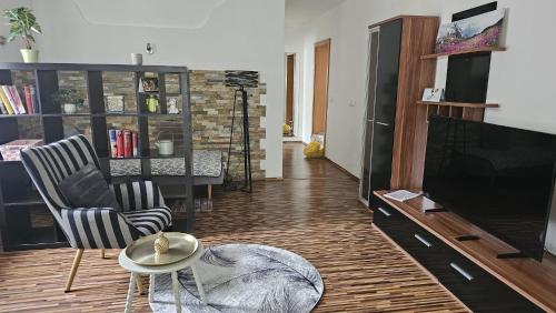 UlmerfeldにあるApartment im Zentrum Ulmerfeldsのリビングルーム(テレビ、椅子2脚、テーブル付)