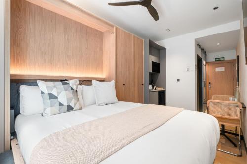 a bedroom with a large white bed with a wooden headboard at Dobo Madrid Moncayo in Madrid