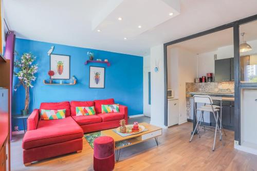 - un salon avec un canapé rouge et un mur bleu dans l'établissement United Colors Of Clermont, à Clermont-Ferrand