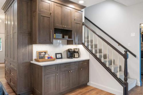 a kitchen with wooden cabinets and a staircase at Rolling Hills Family Home in Branson West