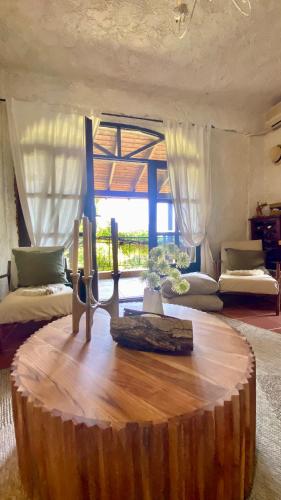 a living room with a large wooden table with a large window at Koti Mountain House in Litochoro