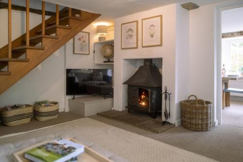 a living room with a fireplace and a staircase at Danny Lodge - Country Cottage Near Brighton by Huluki Sussex Stays in Hurstpierpoint