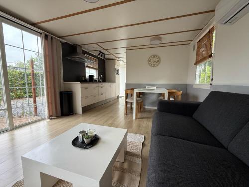 a living room with a couch and a table at 89, Groenvink - one with nature! in Oisterwijk