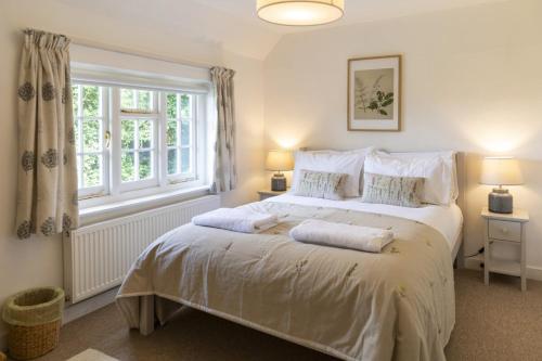 une chambre avec un grand lit blanc avec deux oreillers dans l'établissement Danny Lodge - Country Cottage Near Brighton by Huluki Sussex Stays, à Hurstpierpoint