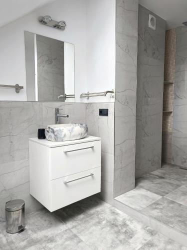a white bathroom with a sink and a mirror at Ranczo Nowodworce - pokoje do wynajęcia in Nowodworce