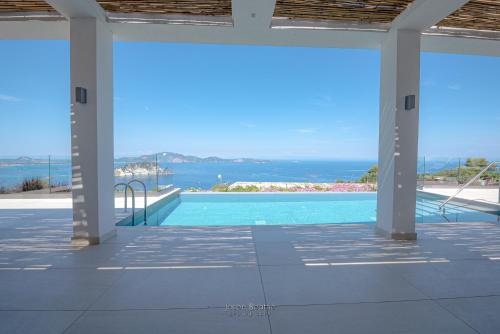 a swimming pool with a view of the ocean at Lamar Private Luxury Villas in Marathias