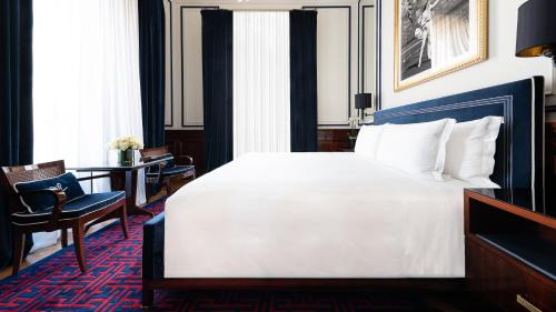 a bedroom with a large white bed and a desk at Casa Cipriani Milano in Milan