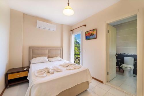 Un dormitorio con una cama con toallas. en Villa TURUNÇ - Göcek, en Fethiye