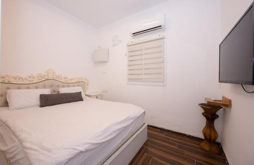 a bedroom with a bed and a flat screen tv at ויקטוריה - ווילה מהממת עם ממ"ד ובריכה פרטית בכלנית in Kallanit