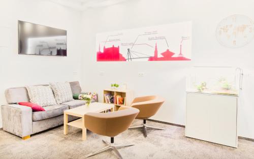 a living room with a couch and a table and chairs at Pension Petit in Bratislava