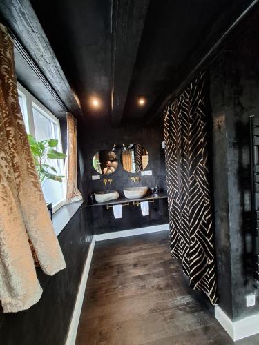 a bathroom with black walls and a room with sinks at Bahnhofsoase - Wellness & Spa am Krufter Bahnhof in Kruft