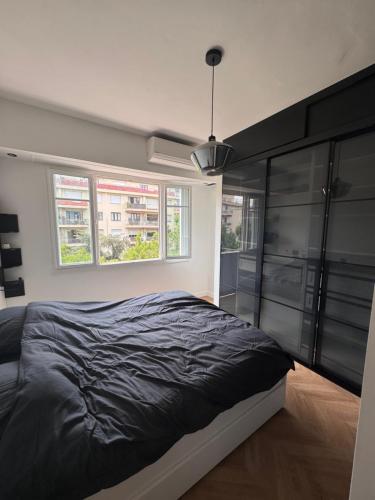 une chambre avec un grand lit et deux fenêtres dans l'établissement Beautiful 2-room, AC, Center, terrace, à Nice