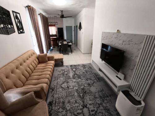 a living room with a couch and a flat screen tv at A&L NilamHomestay in Seremban