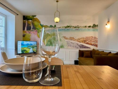 - une table avec deux verres à vin et un ordinateur portable dans l'établissement Les Jardins du Théâtre - Élégance, Bois & Design, à Quimper