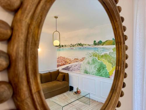 un miroir reflétant un salon avec une grande fenêtre dans l'établissement Les Jardins du Théâtre - Élégance, Bois & Design, à Quimper