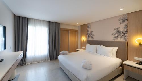a bedroom with a large white bed and a window at Pickalbatros Palais Des Roses - Agadir - All Inclusive in Agadir