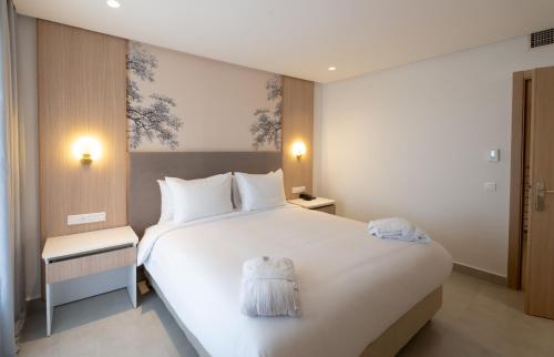 a bedroom with a large white bed in a room at Pickalbatros Palais Des Roses - Agadir - All Inclusive in Agadir