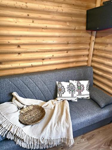 a gray couch with a basket on top of it at Grota zbójnicka apartament i pokoje in Gliczarów