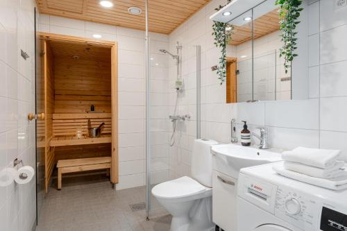 a bathroom with a toilet and a sink and a shower at "Pyynikinkulma" - 1BR Apt with Stunning Views, Sauna & Balcony in Tampere