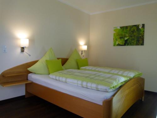 Mosel-Apart Rudorfer في فلاويخ: غرفة نوم صغيرة مع سرير مع وسائد خضراء