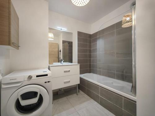 une salle de bain avec un lave-linge et une baignoire dans l'établissement 2 bedrooms apartment Sea View Pool WiFi Parking CLIM, à Vallauris