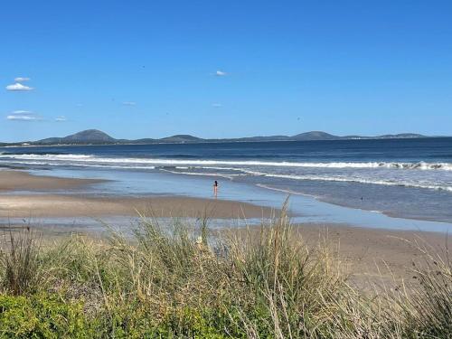 a person standing on a beach near the ocean at Casa completa Balneario Argentino in Balneario Argentino