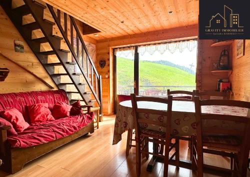 un salon avec un canapé rouge et une table dans l'établissement 3 chambres - skis au pied, au Grand-Bornand