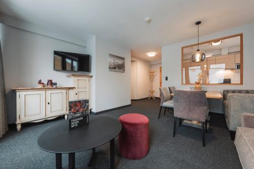 a living room with a couch and a table and chairs at Leni Mountain Appartements in Sölden