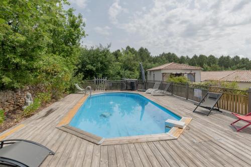une grande piscine sur une terrasse en bois dans l'établissement Le Pequelet, à Payzac