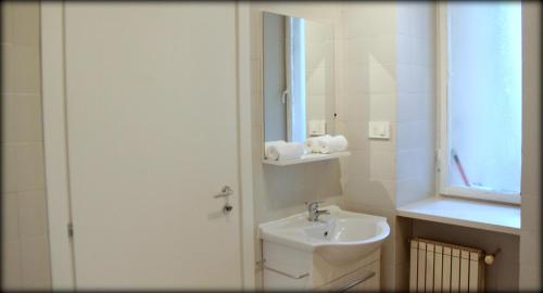 トリノにあるToscana's Home Apartmentの白いバスルーム(シンク、鏡付)