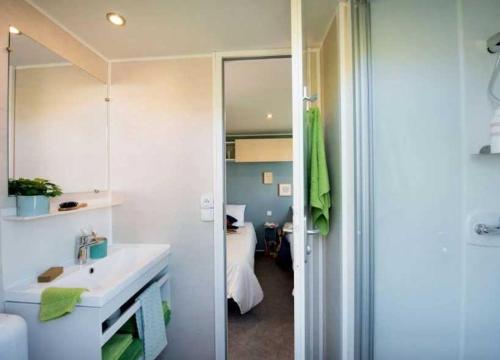 La salle de bains est pourvue d'un lavabo et d'un miroir. dans l'établissement Camping - Parc aquatique - ccafhb0, à La Baule